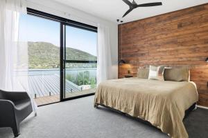 Un dormitorio con una cama y una pared de madera. en Kohatu Ora, en Queenstown