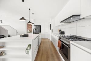 cocina con encimeras blancas y fogones en Kohatu Ora, en Queenstown