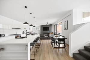 cocina abierta y comedor con encimeras blancas en Kohatu Ora, en Queenstown