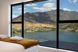 1 dormitorio con ventana grande con vistas al lago en Elevated Elegance, en Queenstown