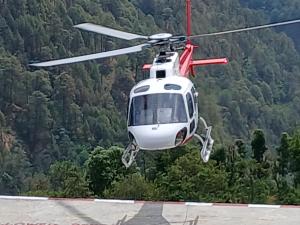 a helicopter is flying over a runway at Rudraksh home stay and restaurant in Phata +4 photos