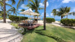 a table with a white umbrella on the beach at Luxurious Apartment La Amada Ocean View in Cancún