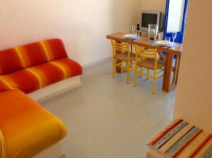 a living room with a table and a couch and a chair at Dimora Tipica Vista Mare in Marettimo