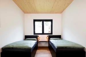 two beds in a room with a window at Hinterland&See in Tettnang