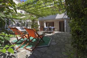 un patio con 2 sillas, una mesa y una pérgola en Apartments Kump, en Rovinj