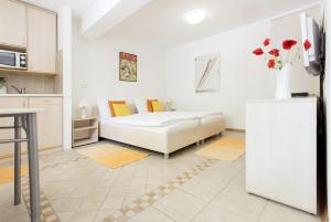 sala de estar blanca con cama y nevera en Apartments Kump, en Rovinj