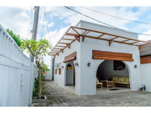 a white building with an archway and a patio at Arthas Villa Nusa Penida in Polilit