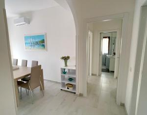 una cucina e una sala da pranzo con tavolo e sedie di SEA PEARL Boutique Apartment - Bright and spacious, with modern Mediterranean décor, just 100 meters from the Lavinio seafront ad Anzio