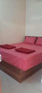 a bed with red sheets and red pillows on it at Bhagini Residency Rooms in Bangalore