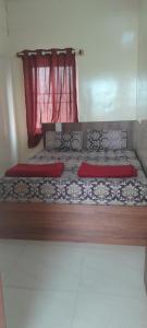 a bed with two red pillows in a room at Bhagini Residency Rooms in Bangalore