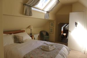 Schlafzimmer mit einem Bett und einem Dachfenster in der Unterkunft Knapp House Lodges in East Anstey