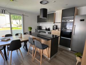 a kitchen with a wooden table and a kitchen with black appliances at Le Clos Les Brunes in Limoges