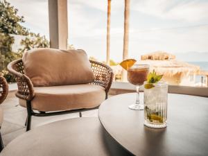 a coffee table with a chair and a drink on it at Sagredo Boutique Hotel & Spa in Ágios Fokás