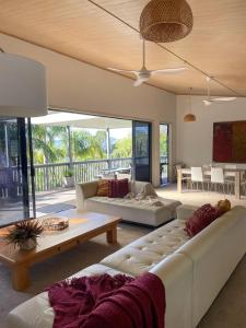 a living room with two couches and a table at Harrisons Retreat Premium Stay in Cable Bay