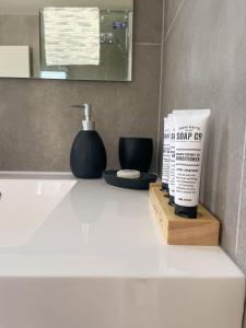 a bathroom counter with a bottle of lotion and a mirror at Harrisons Retreat Premium Stay in Cable Bay