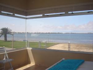 a room with a large window with a view of the ocean at Lagoon View Self Catering in Walvis Bay