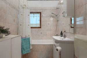 łazienka z białą wanną i umywalką w obiekcie Komplett umzäuntes Ferienhaus mit Klima, WLAN w mieście Rakalj +33 zdjęcia