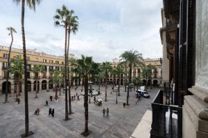 a city street filled with lots of palm trees at Pensión Villanueva in Barcelona