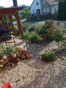 a garden with a bench and flowers in a yard at Rózsa vendégház in Zirc +39 photos
