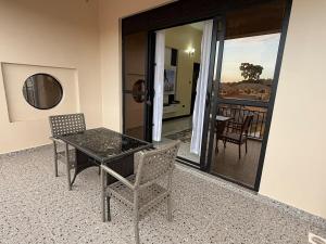 a table and chairs in a room with a balcony at Uptown retreat home Su casa Najjera 1 in Buwate