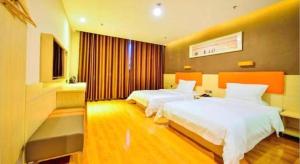a hotel room with two beds and a television at 7 Days Premium·Shihezi Passenger Terminal in Shihezi