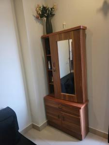 a wooden cabinet with a mirror in a room at Urban Escape Comfy Appartment in Dargai
