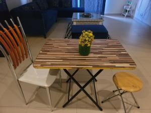 a wooden table with a vase of flowers and two chairs at Urban Escape Comfy Appartment in Dargai
