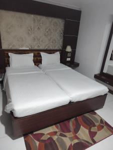 two beds sitting next to each other in a room at Airport City Hotel 