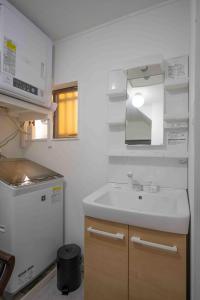 a small kitchen with a sink and a refrigerator at Beach & Stay 鎌倉長谷 暮らすように泊まる 長谷駅すぐ 海近の個室ゲストハウス in Kamakura