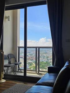a room with a large window with a view of a city at Condo Sea view Beach U 34 in Pattaya South