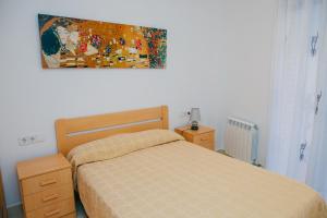 バルセロナにあるアパルタメントス ナバスのベッドルーム1室(ベッド1台付)が備わります。壁には絵画が飾られています。