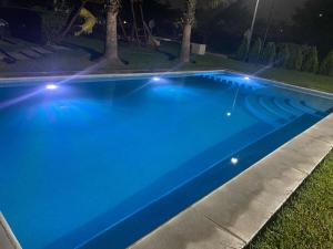 a blue swimming pool with lights on the grass at Departamento en Boca del Rio Ver in Boca del Río