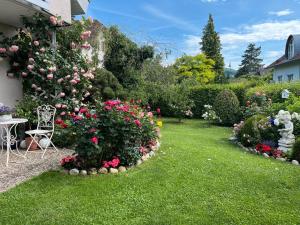 エーニンゲンにあるFerienwohnung Klosterblickのピンクのバラが飾られた庭園(テーブル、椅子付)