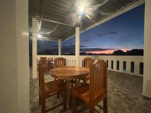 a dining room with a table and chairs on a balcony at FOUR-G Home Stay & Komodo Tour in Labuan Bajo