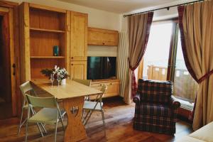 a living room with a table and chairs and a television at Maison Carrel Elegant 12 in Breuil-Cervinia