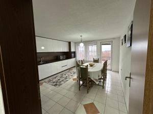 a kitchen and dining room with a table and chairs at A&F apartment in Prishtinë
