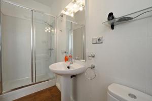 a white bathroom with a shower and a sink at Monrooms Barcelona in Barcelona