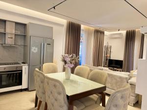 a kitchen and living room with a table and chairs at Villa Bodini Himare in Himare