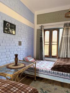 a room with two beds and a window at Gaonvasi Homestay in Uttarkāshi