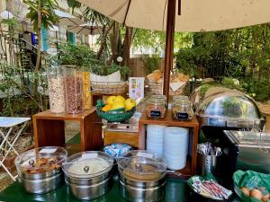 a table with food and bowls of food on it at Le Windsor, Jungle Art Hotel in Nice
