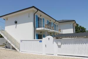 a white house with a white fence and a gate at Casa Ayan in 2 Mai