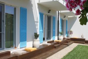 a house with blue shutters and a porch with towels at Casa Ayan in 2 Mai +23 photos