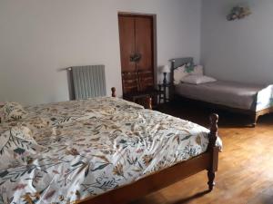 a bedroom with a bed with a floral comforter at Grand gite Chateau in Saint-Paul-lès-Monestier