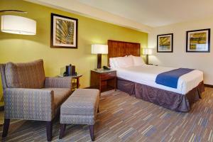 a hotel room with a bed and a chair at Holiday Inn Express San Diego South - National City by IHG in National City
