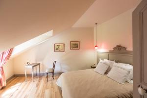 ein Schlafzimmer mit einem Bett und einem Tisch und einem Fenster in der Unterkunft Chateau de Lourdes in Saint-Méloir-des-Ondes