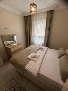 a bedroom with a bed with two towels on it at Karenes KUZEY Pansıyon in Çaykara