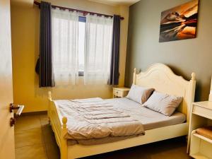 a bedroom with a white bed with a window at Condo Sea view Beach U40 in Pattaya South