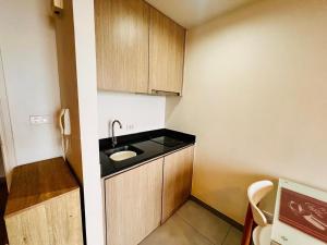 a small kitchen with a sink and wooden cabinets at Condo Sea view Beach U40 in Pattaya South