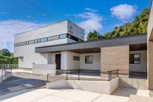 a large white building with a staircase at 最大15名宿泊可 許田ICから車で15分 広々リビングの北部観光におすすめの施設 VILLA de MUI nago in Nago