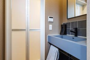 a bathroom with a sink and a mirror at 最大15名宿泊可 許田ICから車で15分 広々リビングの北部観光におすすめの施設 VILLA de MUI nago in Nago +65 photos